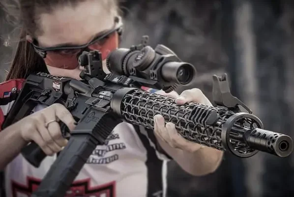 3-gun competitor aiming down her ar15 with a lightweight carbon fiber handguard.