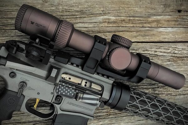 AR15 rifle with long scope and carbon fiber handguard attached.