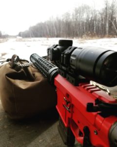 Red cerakoted AR15 with NOAX carbon fiber weave handguard.